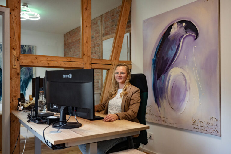 Mitarbeiterin der Prisma Finanzkonzept GmbH während der Arbeit an ihrem Schreibtisch